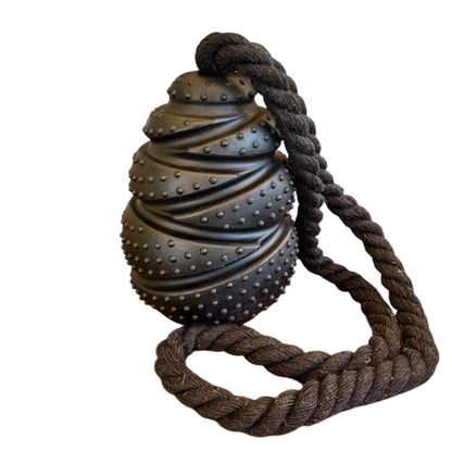 Black textured toy with a rope on a white background