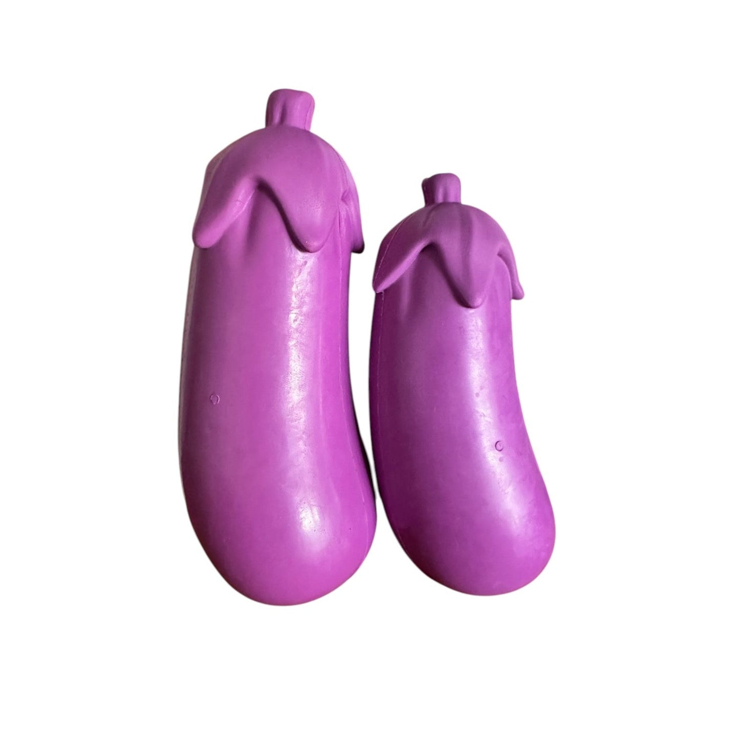 Two purple rubber eggplant tough dog toys.
