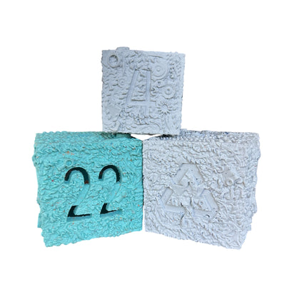 Three chewable rubber boxes with numbers on them.